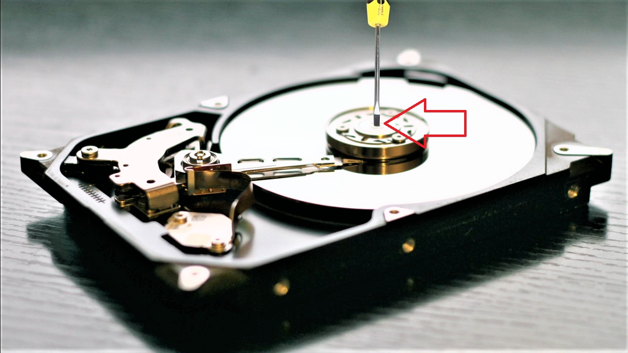 Using the screwdriver to hold the spindle in the middle of the disk